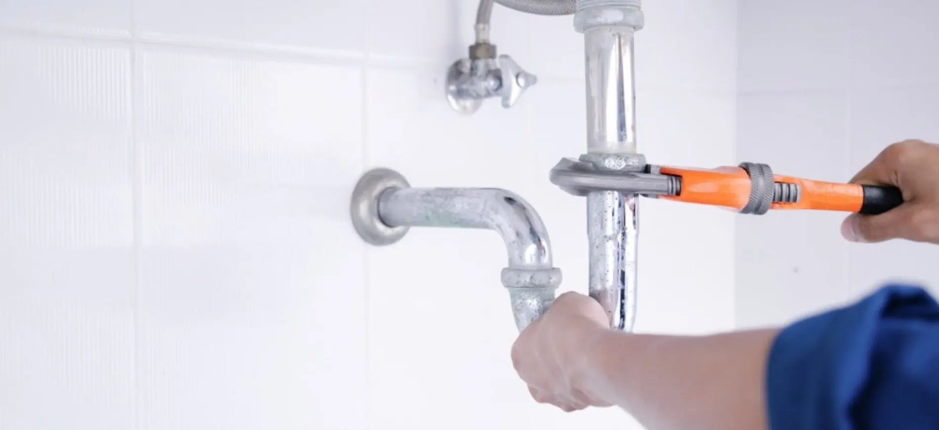 Technician servicing a sink drain P-trap assembly